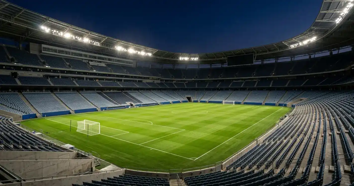 Stadioninnenraum bei Nacht mit leeren Rängen und Flutlicht vor einem K.-o.-artigen Spiel